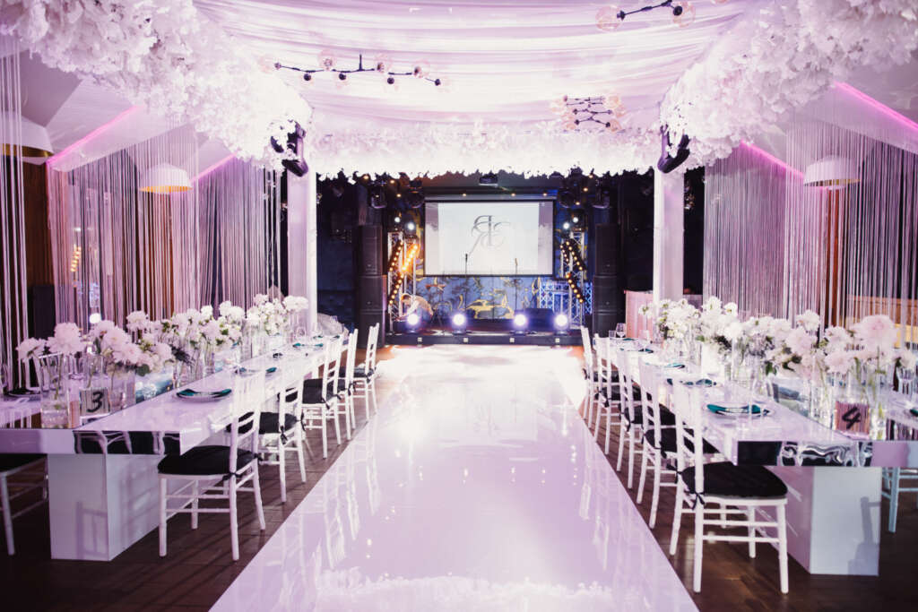 Elegant indoor wedding with pink drapes and flower petals
