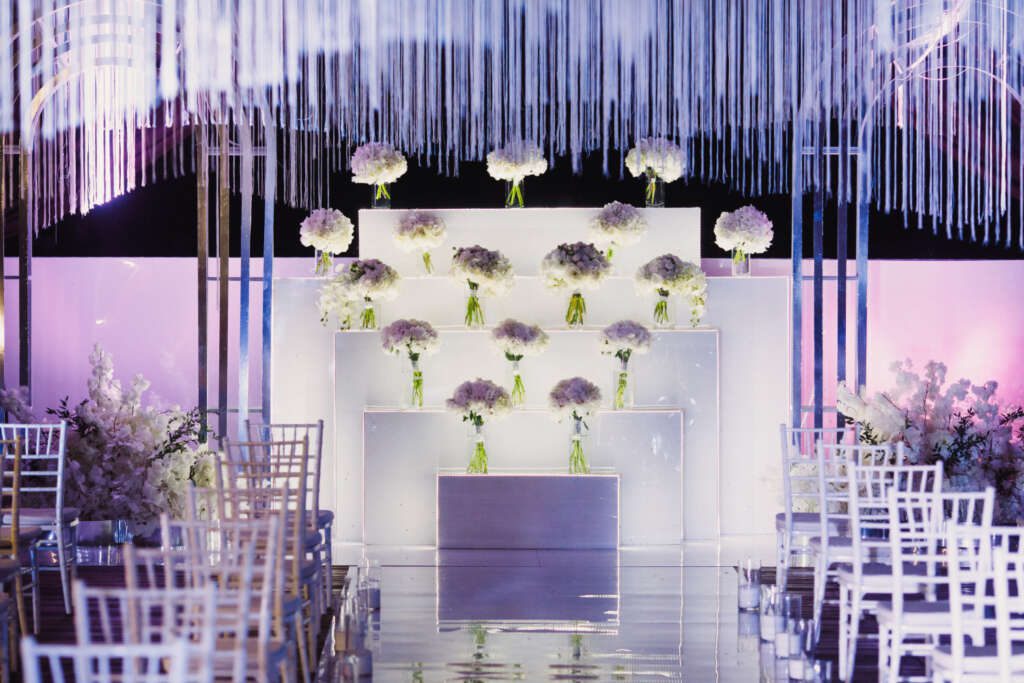 elegant indoor wedding stage with white floral arrangements